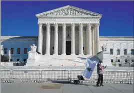  ?? Evan Vucci The Associated Press ?? A person walks by new barricades around the Supreme Court building Thursday.