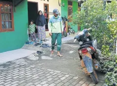  ??  ?? Gravedigge­r Junaedi Bin Hakim, 43, leaves his house to go to work at the Pondok Ranggon cemetery complex.