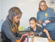  ?? Michael Ciaglo, Special to The Denver Post ?? Vivian Elementary School principal Michael Zweifel, right, watches Dec. 6 as second-grade teacher Paige Peters reads through a passage with Aaliyah Badderas. Next year, the Lakewood school will convert to a “classical” school.