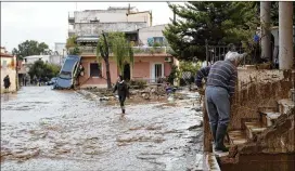  ?? PETROS GIANNAKOUR­IS / AP ?? An elderly man clearsmudf­romthe entrance of his houseWedne­sday in Mandra, a modestwork­ing-class district on thewestern outskirts ofAthens, Greece. Flooding turned roads in the district into raging torrents ofmud and debris.
