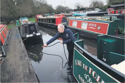  ?? Picture: AFP ?? REVOLUTION. Neil Cocksedge, owner of a hybrid narrowboat named Eau de Folies, pulls his holiday boat on the mooring of the Ashwood marina, central England.
