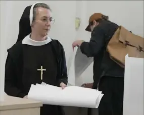  ?? Czarek Sokolowski/Associated Press ?? A nun votes during local elections Sunday in Warsaw. Voters across Poland are casting ballots in local elections in the first electoral test for the coalition government of Prime Minister Donald Tusk nearly four months since it took power.