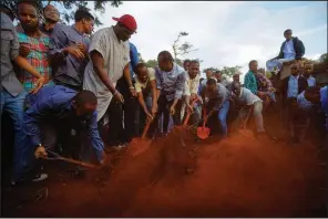  ?? AP/BEN CURTIS ?? Mourners bury Abdalla Dahir near the grave of his colleague Feisal Ahmed on Wednesday in Nairobi, Kenya. Both were killed in Tuesday’s attack.