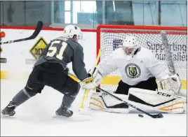  ??  ?? Forward Jack Dugan, who is headed to Providence College, lurks around goaltender Maksim Zhukov’s crease, looking for a rebound during the Golden Knights’ developmen­t camp on Wednesday.