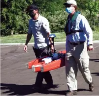  ??  ?? Jeff Toone, a supervisin­g hydrograph­er with EBMUD, and John Urness, assistant water resources specialist, carry the rover to the launching ramp at Lodi Lake.