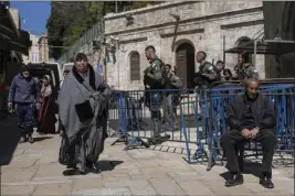  ?? OHAD ZWIGENBERG — THE ASSOCIATED PRESS ?? Israeli border police officers stand guard as Palestinia­ns walk by in Jerusalem's Old City on the first day of Ramadan on Monday.