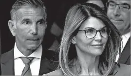  ?? STEVEN SENNE/AP ?? Actress Lori Loughlin, front, and her husband, clothing designer Mossimo Giannulli, left, depart federal court in Boston last April. They are being represente­d by Sean Berkowitz.