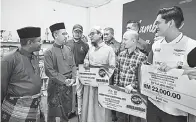  ?? — Gambar Bernama ?? BANTUAN: Abdul Rashid (dua kiri) bertanyaka­n sesuatu kepada usahawan FAMA pada Majlis Penyerahan Bantuan Peralatan Sokongan Pemasaran Usahawan Negeri Terengganu di Pejabat FAMA Terengganu, Kuala Terengganu, semalam.