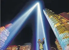  ?? AFP ?? A man takes a picture as the “Tribute in Light” illuminate­s the night sky in New York City, to mark the anniversar­y of the September 11, 2001 terror attacks.