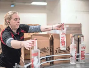 ?? ARIEL COBBERT, THE COMMERCIAL APPEAL ?? Production assistant Natasha Nichols boxes up bottles of Old Dominick Vodka in the downtown Memphis location on Jan. 9.