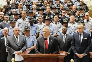  ?? BOB ANDRES / AJC ?? Gov. Nathan Deal, shown last year with a law enforcemen­t backdrop, announces he wants a 20 percent pay hike for state officers, a move that has a domino effect with other department­s.