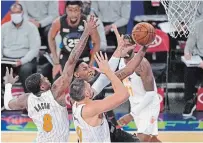  ?? KATHY WILLENS THE ASSOCIATED PRESS ?? Orlando Magic forward Dwayne Bacon, left, and centre Nikola Vucevic, right, defend Knicks guard RJ Barrett, centre, from Toronto, as Barrett goes up for a layup Monday in New York. Barrett scored 22 points and had 10 rebounds in a 91-84 Knicks victory. For the result of Monday night’s Dallas Mavericks vs. Toronto Raptors game, visit our website.