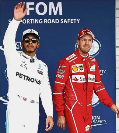  ??  ?? Friendly rivals: Mercedes driver Lewis Hamilton of Britain and Ferrari’s Sebastian Vettel acknowledg­ing the fans after the final qualifying round at the Japanese Grand Prix at Suzuka. — AP