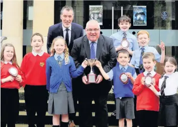  ??  ?? Book worms Burnside pupils Fraser Welsh and Molly Hanratty pick up the award from South Lanarkshir­e Council’s Davie Watson