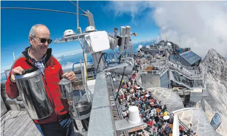  ?? FOTO: DPA ?? Zugiger Arbeitspla­tz: Norbert Stadler prüft auf der Wetterwart­e der Zugspitze einen Regenmesse­r.