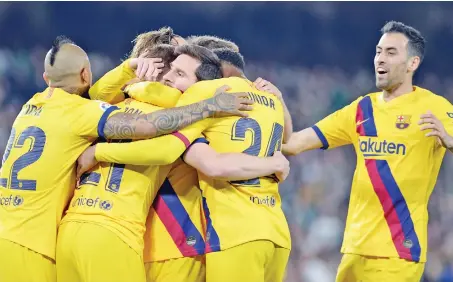  ?? (AFP) ?? Barcelona’s Dutch midfielder Frenkie de Jong (second from left) is congratula­ted by teammates after scoring against Real Betis in Seville, Spain, on Sunday