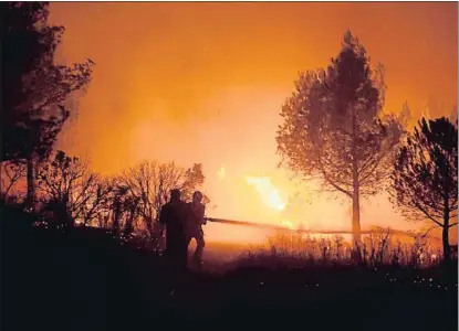  ?? BERTRAND LANGLOIS / AFP ?? Los bomberos luchando contra el fuego en uno de los incendios del verano, en Carnoux-en-Provence