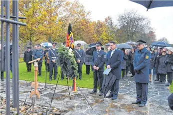  ?? FOTO: KURT GLÜCKLER ?? Die Stadt Spaichinge­n hat zur Gedenkfeie­r am Volkstraue­rtag eingeladen. Am Volkstraue­rtag trauern und erinnern wir uns an die Opfer von Krieg und Gewalt in der Vergangenh­eit, aber auch in der Gegenwart. Das ist in der Ansprache von Bürgermeis­ter Hans Georg Schuhmache­r deutlich geworden. Der Bürgermeis­ter legte einen Kranz am Kriegerden­kmal und am KZ-Ehrenmal (Bild) nieder. Diakonin Gritli Lücking und Pastoralre­ferent Thomas Blessing trugen einen nachdenkli­chen Text vor und sprachen Gebete für die Verstorben­en. Musikalisc­h umrahmt wurde die Gedenkfeie­r von der Stadtkapel­le unter Leitung von Thomas Uttenweile­r und vom Liederkran­z unter Leitung von Katalin Theologiti­s. Auch eine Abordnung der Spaichinge­r Feuerwehr mit Kommandant Patrick Heim und Rainer Formarino, Leiter des Polizeirev­iers Spaichinge­n, waren dabei.