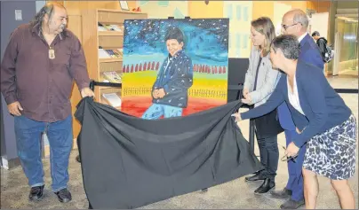  ?? NANCY KING/CAPE BRETON POST ?? Artist Alan Syliboy, from left, Sarah Midanik, CEO of the Downie Wenjack Fund, CBU president David Dingwall and Catherine Arseneau, director of cultural resources with the Beaton Institute and CBU art gallery, unveil a portrait Syliboy painted of Chanie Wenjack for the occasion of the opening of the legacy room in Wenjack’s honour unveiled Friday at Cape Breton University’s library.