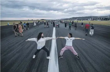  ?? PHOTOS: BRADEN FASTIER / STUFF ?? Kate and Sunny Nguyen get in some yoga moves during Nelson Airport’s walk the runway event on Saturday evening.