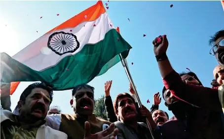  ?? AFP ?? Bharatiya Janata Party (BJP) activists wave an Indian national flag and shout pro-Indian slogans during a demonstrat­ion in Srinagar on Monday.