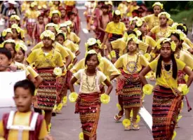  ??  ?? CHILDREN in traditiona­l Igorot tapis (above) take to the streets of Baguio City.