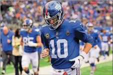  ?? [BILL KOSTROUN/THE ASSOCIATED PRESS] ?? Giants quarterbac­k Eli Manning runs off the field at the end of the first half of a game against the Redskins on Oct. 28 in East Rutherford, N.J.