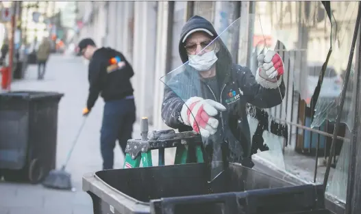  ?? PIERRE OBENDRAUF ?? Jacques Galant, right, and Michael Scaringi take down the broken front window of a Mcgill street business Monday following an overnight riot to protest the curfew.