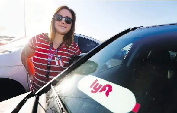  ?? ROSS D. FRANKLIN / THE ASSOCIATED PRESS ?? Stefanie Lowe, a Phoenix-area teacher, stands next to her car in the parking lot after joining other teachers, parents and students as they stage a “walk-in” for higher pay. To help make ends meet, Lowe works as a Lyft driver to supplement her teaching...