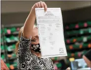 ?? AP PHOTO/MARY ALTAFFER ?? A Lehigh County worker displays a ballot that has a tear in it while they count ballots as vote counting in the general election continues Friday in Allentown, Pa.