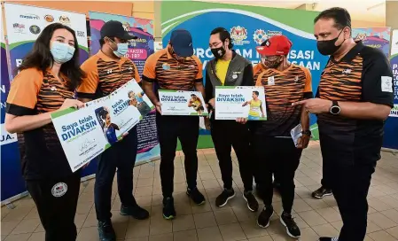  ?? — S.S. KANESAN/The Star ?? Health comes first: Youth and Sports Minister Datuk Seri Reezal Merican Naina Merican (right) talking to the athletes after getting vaccinated at the National Covid-19 Immunisati­on Programme of the Youth and Sports Ministry yesterday.