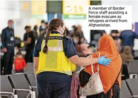  ??  ?? A member of Border Force staff assisting a female evacuee as refugees arrived from Afghanista­n.