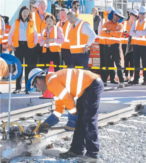  ?? Picture: GLENN HAMPSON ?? and Minister for Transport Jackie Trad and Mayor Tom Tate view the final rail weld at Helensvale.