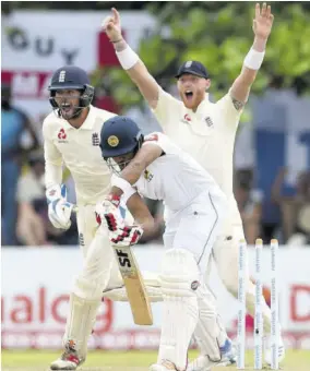  ??  ?? Sri Lanka’s captain Dinesh Chandimal (centre) is bowled as England’s Ben Foakes (left) looks on during the fourth day of the opening Test match at the Galle Internatio­nal Stadium in Galle yesterday.