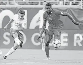  ?? John Raoux / Associated Press ?? Brazil’s Phillippe Coutinho fires a shot past Haiti’s Romain Genevois for one of his three goals Wednesday night.