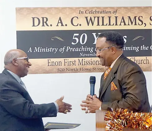  ?? Staff photos by Neil Abeles ?? ■ Atlanta City Council Member Chris Collins, right, proclaims Sunday, Nov. 24, “Pastor Alford C. Williams Sr. Day in Atlanta, Texas.” Williams, left, has risen to shake hands with the councilman, who is representi­ng Mayor Travis Ransom.