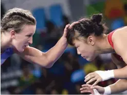  ??  ?? Data from the EHR helped the U.S. women’s wrestling squad adjust its training to avoid injuries. The U.S.’ Haley Ruth Augello, in blue, competes against Japan’s Eri Tosaka during the women’s 48-kg. freestyle wrestling competitio­n.