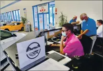  ?? DAVID DEGNER — THE NEW YORK TIMES ?? Sales staff work at Silko Honda in Raynham, Massachuse­tts. The owner says the value of used cars has taken a surprise turn higher.