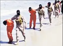  ??  ?? THE EVIL CONTINUES: Masked ISIS savages march a group of Ethiopian Christians to their deaths.