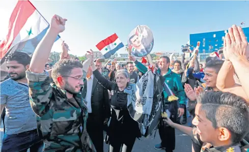  ??  ?? SHOW OF SUPPORT: Syrians wave the national flag and portraits of President Bashar al-Assad in Damascus as they condemn strikes carried out by the US, Britain and France.