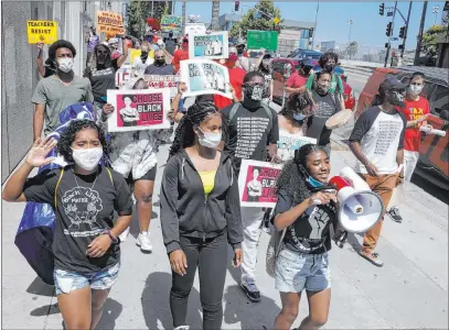  ?? Marcio Jose Sanchez The Associated Press ?? Demonstrat­ors march Monday in Los Angeles. Parents, students, and teachers held a news conference and car caravan to call for a safe, fully funded, and racially just approach to the reopening of Los Angeles schools.