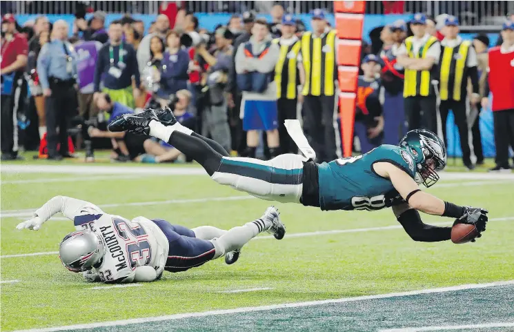  ?? — THE ASSOCIATED PRESS ?? Philadelph­ia Eagles tight end Zach Ertz dives over New England Patriots safety Devin McCourty to score the winning touchdown in Super Bowl LII.