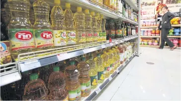  ?? JIRAPORN KUHAKAN ?? Bottles of cooking palm oil on display at a supermarke­t in Bangkok.