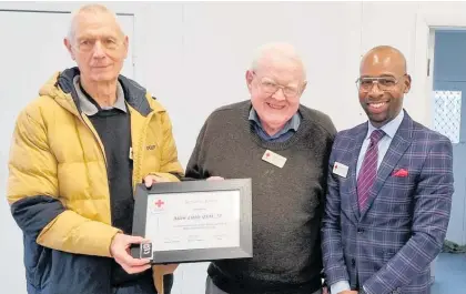  ?? ?? Red Cross regional chairman Don Thomas (yellow jacket) and Red Cross national humanitari­an developmen­t manager Peter Barnor Sabo presented Allen Little with his service award.