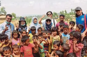  ?? PIX BY FAIZ QAYYUUM ?? The Malaysian volunteers with Rohingya children. (From left) Husin (local interprete­r), Fathihah Saman, Nur Akmal Izyan, Faiz Qayyuum (dark glasses, behind), Zatul Iftah and Aariq Armiza.