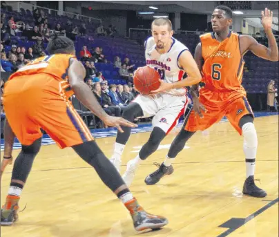  ?? JEREMY FRASER/CAPE BRETON POST ?? Joey Miller, centre, of the Cape Breton Highlander­s, drives to the basket as Franklin Session, right, of the Island Storm looks on during National Basketball League of Canada action at Centre 200, Friday. The Highlander­s won the game 117-113.