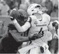  ?? AP Photo/L.G. Patterson ?? ■ Arkansas quarterbac­k Ty Storey, right, fumbles the ball as he is hit by Missouri defensive lineman Jordan Elliott Friday in Columbia, Mo.
