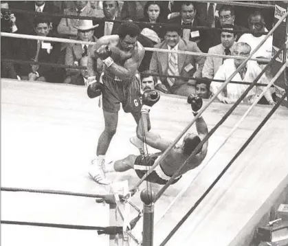  ?? Associated Press ?? GEORGE FOREMAN knocks down Ken Norton in the second round of their 1974 world title bout in Caracas, Venezuela. Bill Caplan, who was Foreman’s publicist, remembers that he and the champion had a hard time getting out of the country.