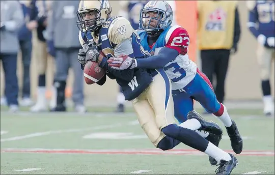  ?? — THE CANADIAN PRESS ?? Winnipeg Blue Bombers’ Doug Pierce snags a pass despite being wrapped up by Montreal Alouettes’ Seth Williams during the first half of their CFL game in Winnipeg on Saturday.