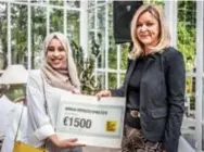  ??  ?? Assia Tiane(23) krijgt als winnares van de Diversitei­tsprijs een bijbehoren­de cheque uit handen van HBvL-hoofdredac­teur Indra Dewitte.